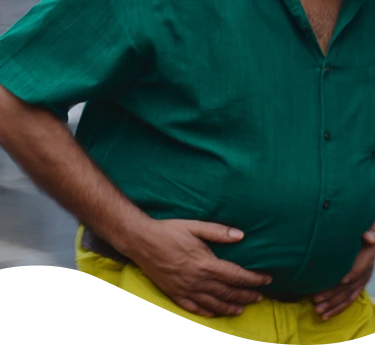 Hombre con chomba con cara de dolor mientras sostiene una hamburguesa y unas papas fritas